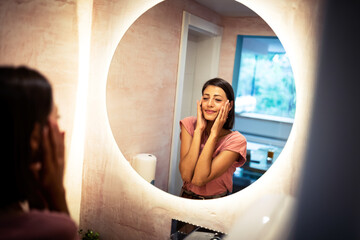 Wall Mural - Mirror reflection of a woman worrying because of wrinkles on her forehead.