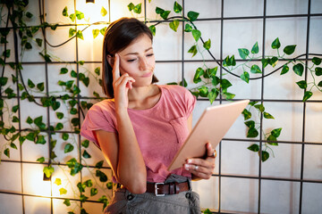 Confused shocked beautiful young woman looking at tablet computer