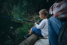 Little Boy Fishing Outdoor On The Lake With His Grandfather