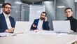 © BullRun - Male and female experts sitting at table desktop and using technology for informative research and web projecting, experienced proud ceo with smartphone for call cooperate in office with colleagues
