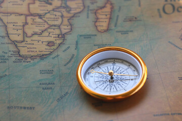 Wall Mural - classic round compass on background of old vintage map of world as symbol of tourism with compass, t