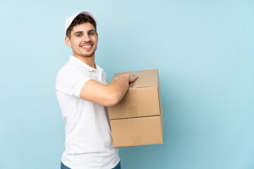 Delivery caucasian man isolated on blue background laughing