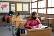 © Wavebreak Media - Girl wearing face mask studying while sitting on her desk at school