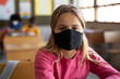 © Wavebreak Media - Portrait of girl wearing face mask sitting in the class at school