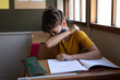 © Wavebreak Media - Boy wearing face mask sneezing while sitting on his desk at school