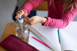 © Wavebreak Media - Mid section of a girl sanitizing her hands while sitting on her desk at school