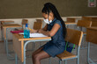© Wavebreak Media - Black African American Girl wearing face mask sitting on her desk at school