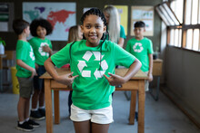 Portrait Of Girl Showing Her Recycle T Shirt In Class At School