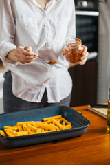 Canvas Print - Female chef seasoning sweet potato fries in a pan