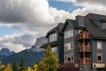 Wall Mural - Wooden building with rocky mountains in autumn forest on downtown at Canmore