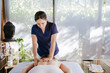 © Eva Blanco/Westend61 - Mid adult woman giving back massage to female customer lying on table in spa