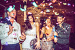 © EDUARDOHUELINPHOTO/Westend61 - Male and female friends with champagne and disco ball dancing amidst confetti in party