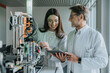 © Mareen Fischinger/Westend61 - Mature man showing digital tablet to female colleague while standing by machinery in laboratory