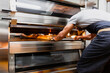 © Manu Reyes/Westend61 - Baker baking bread in oven at bakery