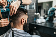 © hedgehog94 - Good looking bearded man visiting hairstylist in barber shop.