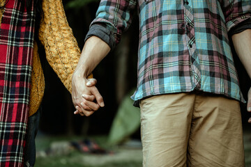 Wall Mural - Young couple in love walking in the autumn park holding hands 
