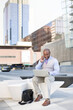 © Alfredo López - Black businessman talking to his smartphone while operating his laptop on the street. Concept of new ways of business. Space for text.