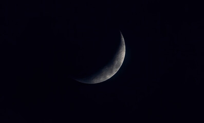 sickle shaped moon on the night sky