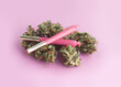 cannabis joint with bud and grinder on pink background. Women and weed concept.