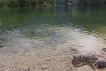 klares Wasser an einem stillen see mit steinen