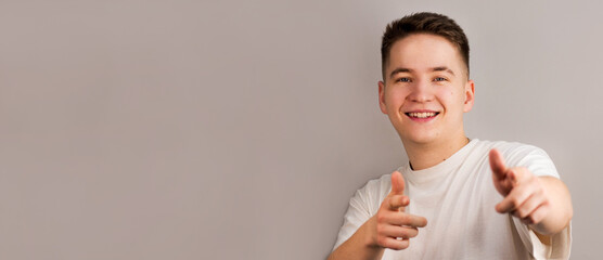 Portrait of happy man with white t-shirt against light gray background. studio shot.