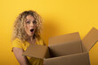 © alphaspirit - Happy woman receives a package from online shop order. Yellow background.
