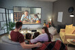 © Pixel-Shot - Young family watching movie at home