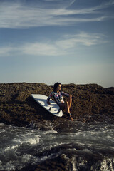 Poster - Vertical shot of a caucasian woman surfing