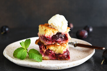 Cupcake with plums and vanilla ice cream on a dark background. Fruit pie with mint.