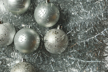 gray christmas balls and beautiful shiny tinsel. the decor for the celebration of merry christmas an