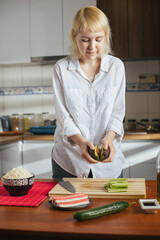 Canvas Print - Female chef cutting avocado in a home kitchen