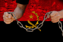 Male Hands Breaking The Iron Chain, Symbol Of Bondage, Protest Against The Background Of The State Flag Of Angola, The Concept Of Political Repression, Tyranny, Arrest, Crime, Civil Rights, Freedom