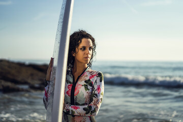 Sticker - Beautiful young surfer woman  with a surfboard having fun on the beach