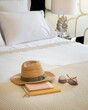 Detail of a bed with books hat and sun glasses