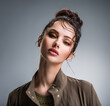 Leinwandbild Motiv Closeup portrait of a beautiful young fashion woman with glamour makeup posing at studio.