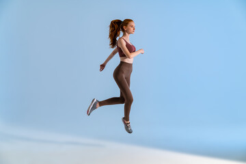 Wall Mural - Photo of athletic focused sportswoman jumping while working out