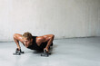Photo of athletic young sportsman working out with push-up stops
