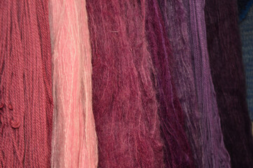 Sticker - Closeup of different pink and purple colored fabric wools in a market