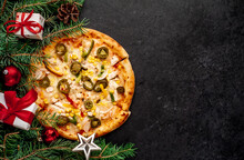 Mexican Pizza For Christmas With Chicken Fillet, Mozzarella Cheese, Peppers, Tomatoes, Onions, Corn, Bell Peppers With Christmas Decorations, Gifts, Spruce, Toys On Wood Background With Copy Space 