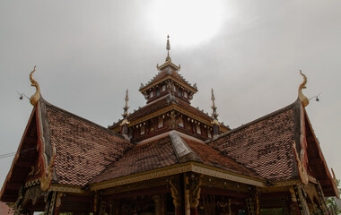 Wall Mural - Ancient wooden roof on Buddhist temple in Wat Pratu Pong at Lampang Province. Beautiful temple built in a mix of Lanna and Burmese Shan styles. Selective focus.