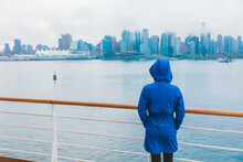 Autumn City Scenery Woman Walking Alone Under The Rain Wearing Blue Raincoat In Wet Cold Day. Skyline Of Vancouver, Canada. Cruise Ship Travel Destination.