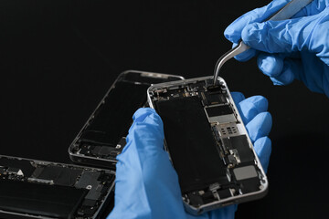 Technician repairing the Cell phone parts and tools for recovery repair phone smartphone and upgrade mobile technology,the concept of computer hardware inside.