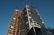 Hochhaus Neubau vor blauem Himmel im Licht der Abendsonne aus der Froschperspektive mit Baukran und Baugerüst im Westend von Frankfurt am Main in Hessen