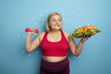 Fat Woman Does Gym And Want To Eat A Sandwich. Concept Of Food Temptation