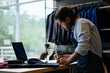 © Vergani Fotografia - Serious latin business man with laptop working at laptop and taking notes inside shop. owner, small business, successful, community concept..