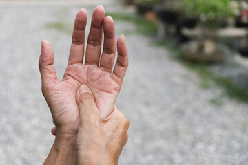 Closeup hand of person massage her hand from pain in healthy concept on nature background.