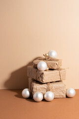 Wall Mural - The paper gift boxes with white christmas balls isolated on beige background. Christmas concept. Flat lay.