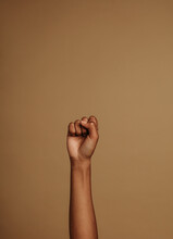 Raised Hand On Brown Background