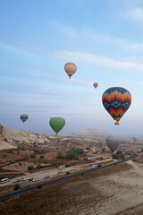 Wall Mural - Colorful hot air balloon ride and tour in Goreme valley, semi-arid region in central Turkey known for its distinctive fairy chimneys, tall, cone-shaped rock formation- Cappadocia, Turkey