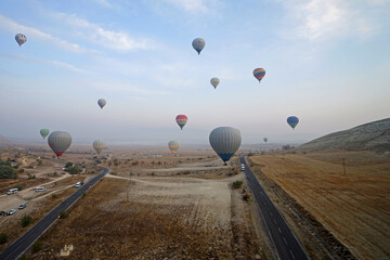 Wall Mural - Colorful hot air balloon ride and tour in Goreme valley, semi-arid region in central Turkey known for its distinctive fairy chimneys, tall, cone-shaped rock formation- Cappadocia, Turkey